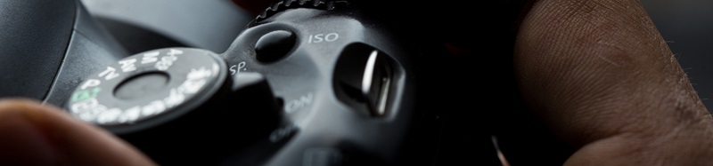 Man's hand holding a DSLR camera stock photo