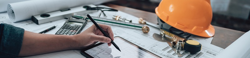 Engineering working with drawings inspection on tablet in the office and Calculator, triangle ruler, safety glasses, compass, vernier caliper on Blueprint. Engineer, Architect, Industry and factory concept.