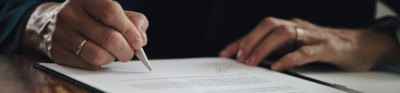 Low angle closeup view of businesswoman signing a document or contract
