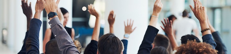 People with hands raised during presentation
