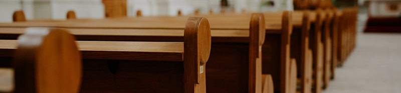 Row of wooden pews in catholic church interior
